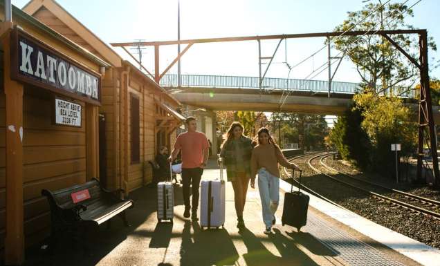 Young people with luggage catching a train at Katoombatrain station.
