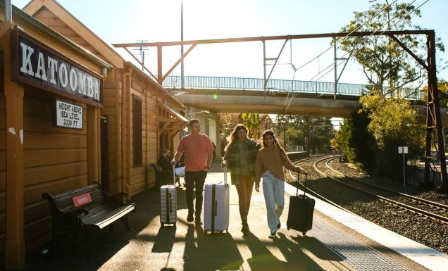 Young people with luggage catching a train at Katoombatrain station.