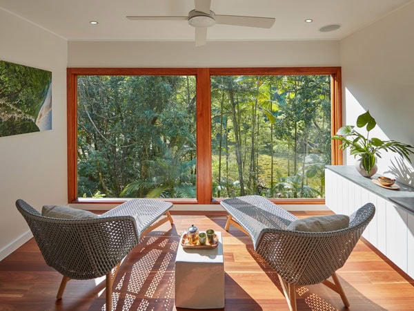 Two chairs fact the window with views of the rainforest at Healing Waters Spa