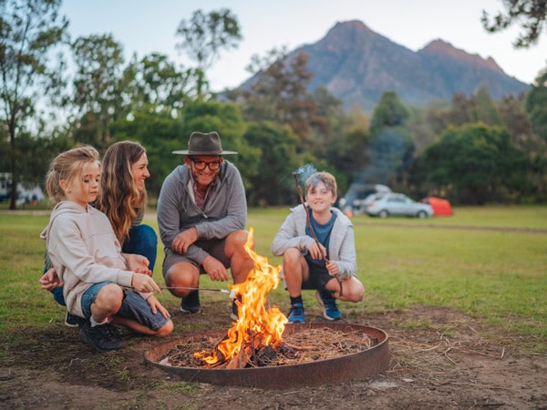 a family sitting around a bonfire at Mt Barney Lodge, Scenic Rim