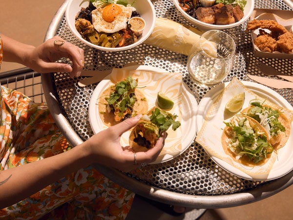 a table-top view of friends enjoying their tacos and beer at Sandy's