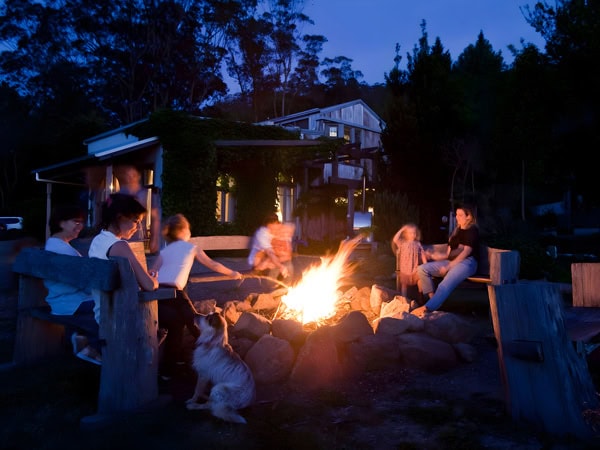 a group sitting around a bonfire at The Shed in Kangaroo Valley