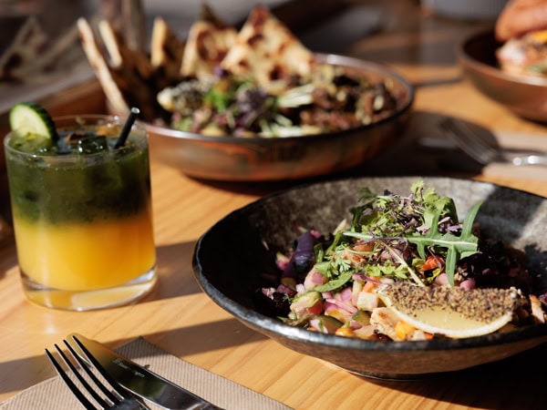 a close-up shot of a food on a plate alongside a drink on the table at Antidote Kitchen