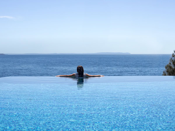 a woman relaxing by tthe edge of an infinity pool at Bannisters By the Sea
