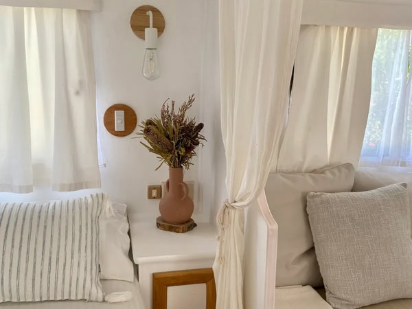 white curtains and comfy cushions in a charming caravan Airbnb at Fremantle