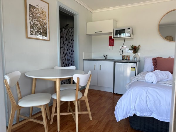 the bedroom with chairs, table and modern amenities at Clare Valley Caravan Park