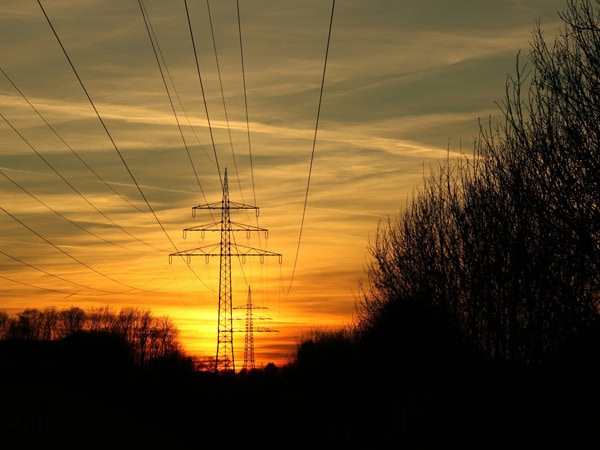 electricity posts and power lines at sunrise