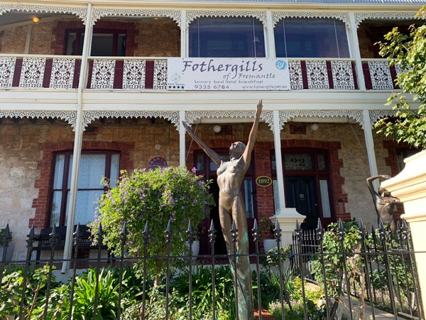 a sculpture of a woman with upraised hands in front of Fothergills of Fremantle property