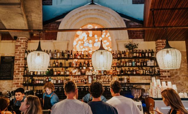 people lining up at the well-lit bar counter of Mr Chapple, Fremantle
