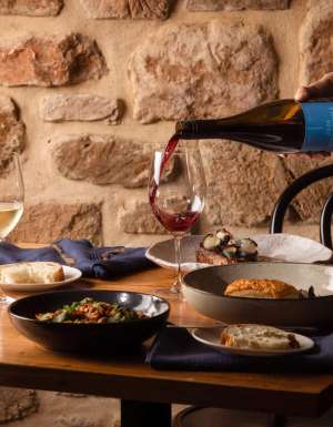 pouring wine into a glass on the dinner table at O’Leary Walker Restaurant