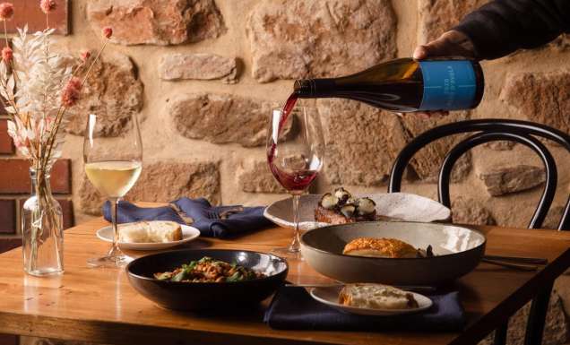pouring wine into a glass on the dinner table at O’Leary Walker Restaurant