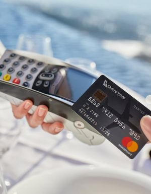 a hand holding a Qantas credit card
