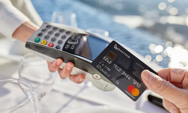 a hand holding a Qantas credit card