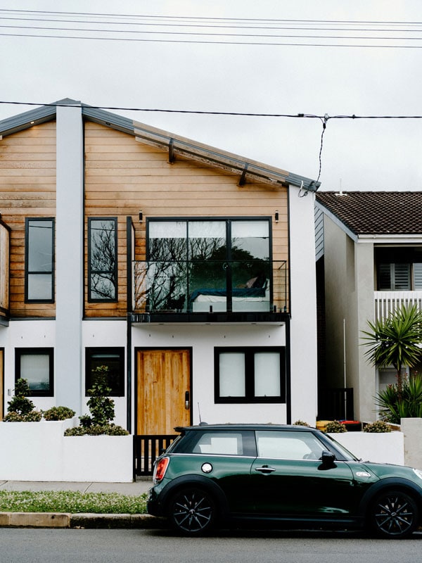 a car parked outside a two-storey house
