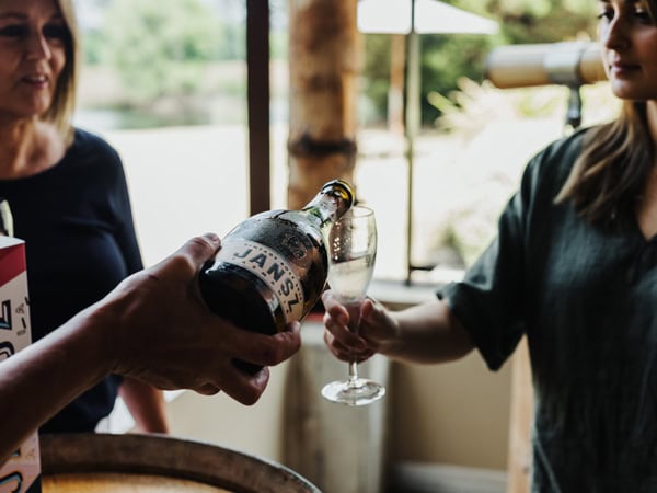 pouring sparkling wine into a glass at Jansz Tasmania