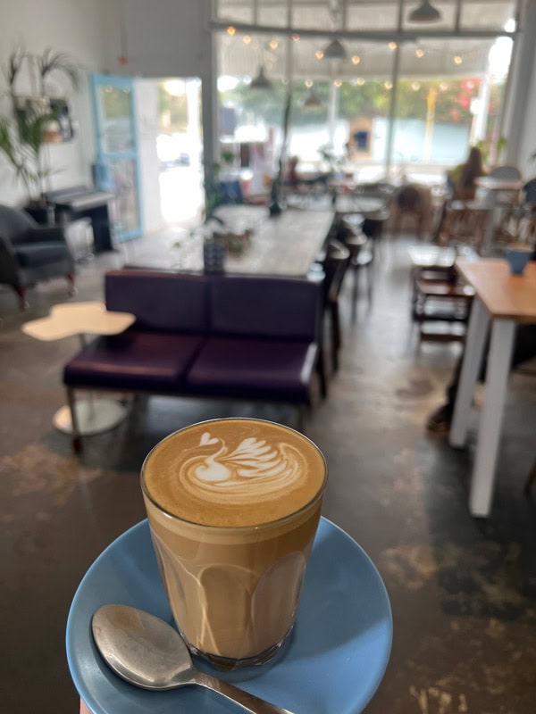a cup of coffee with the cafe interior of Kerfuffle in the background