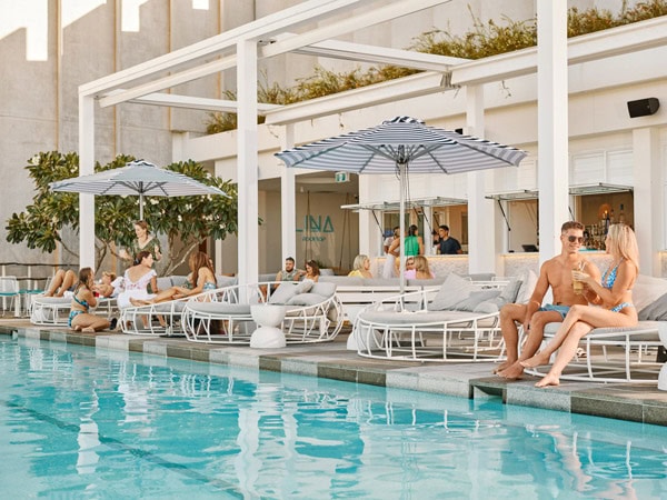 guests relaxing on sun loungers by the pool at Lina Rooftop Bar