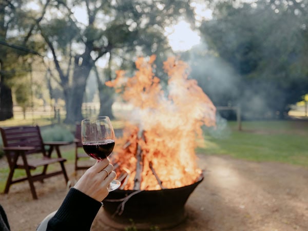 holding a wine glass near the fire at Losari Retreat