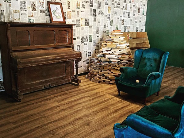 piano and lounge chairs inside The Lost Poet Coffee Bookstore winton