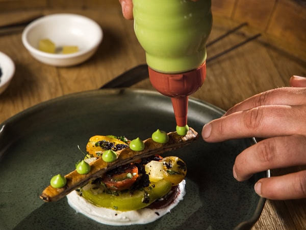 putting green sauce over a food presentation at Mount Lofty Ranges Vineyard Restaurant