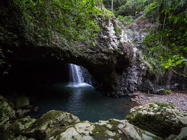 water falling down a large hole at Natural Bridge, Qld