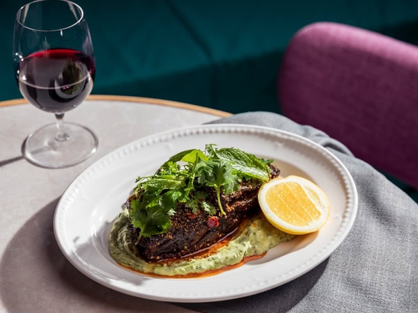 a close-up of food on a plate alongside a wine glass at Penelope’s, Sydney, NSW