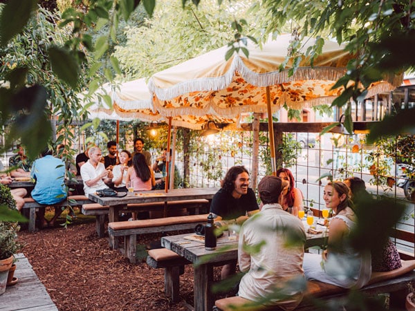 friends dining in tables under huge yellow umbrellas at Peter Rabbit Cafe
