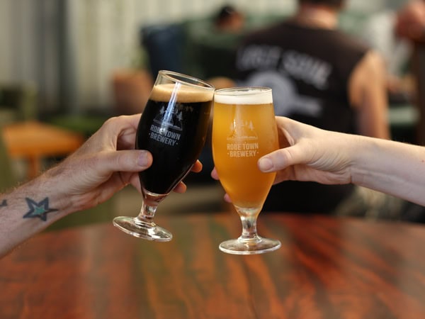 clinking two glasses of beer at Robe Town Brewery