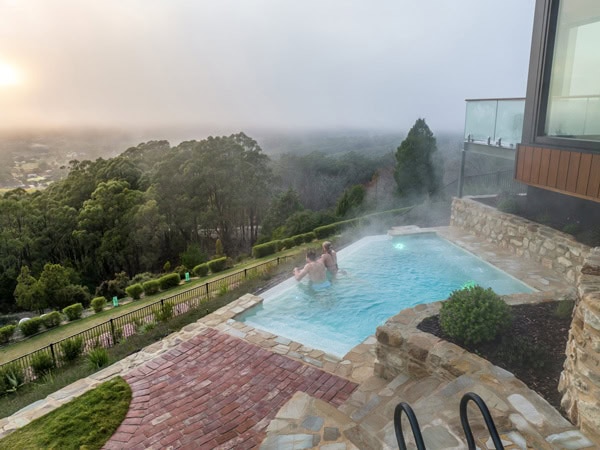 a couple relaxing in the infinity pool at Sequoia Lodge, Mount Lofty