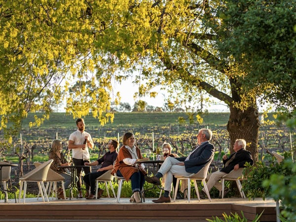 people wine tasting in the outdoor garden area of Shut the Gate Wines