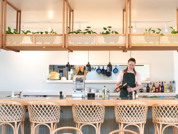 a barista preparing drinks at the counter of Sisterhood Cafe