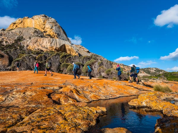 hikers traversing rocky outcrops on Flinders Island