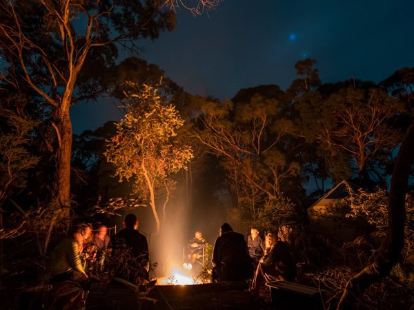 hikers gathering around a fire