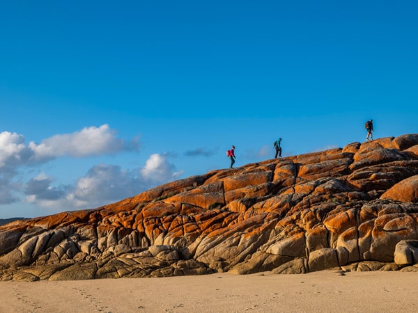 hikers traversing the the rugged granite peaks on Flinders Island