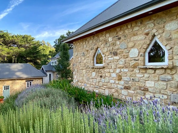 the brick-walled Airbnb surrounded by lavender flowers at The Coach House, Aldgate