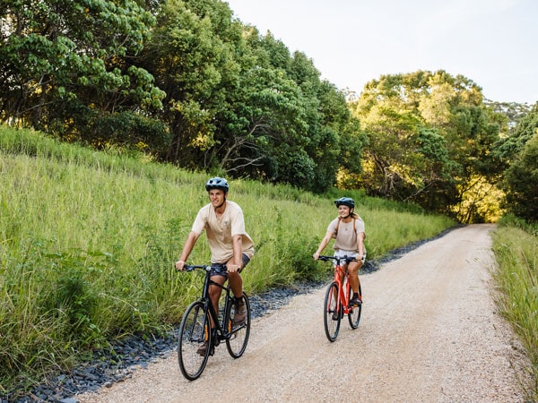two cyclists biking along the Tweed trail