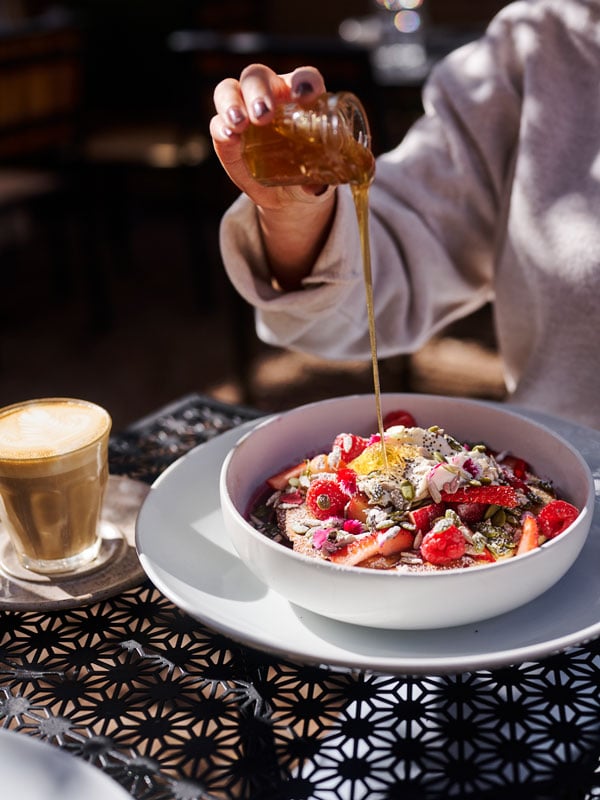 pouring honey over a dish at Two Before Ten cafe