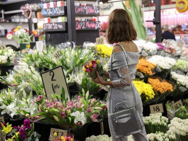 a woman buying fresh flowers at the Adelaide Central Market