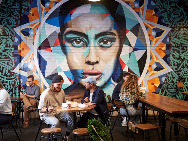 people dining near a vibrant wall art in Adelaide Central Market
