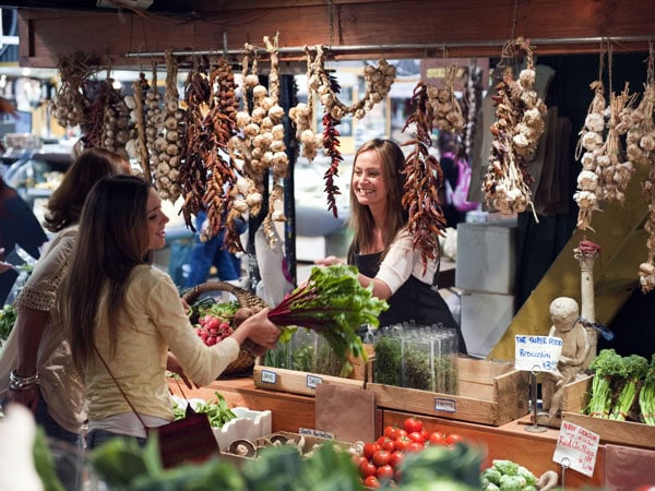 a woman shopping at a fresh produce stall in Adelaide Central Market