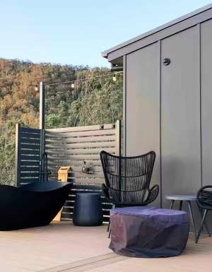 an outdoor deck with a tub at Rosebook Eco Tiny Home, Hunter Valley