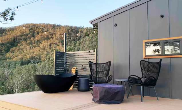 an outdoor deck with a tub at Rosebook Eco Tiny Home, Hunter Valley