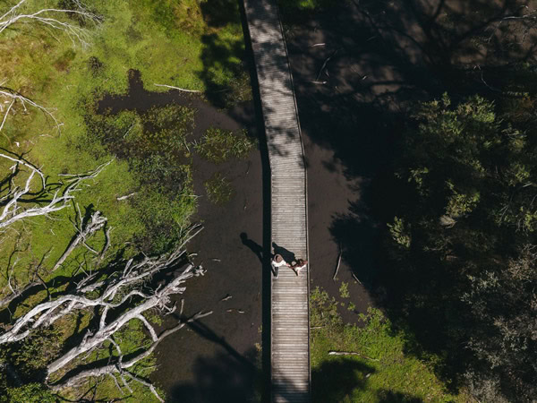 an aerial view of two people walking along the Limestone Coast