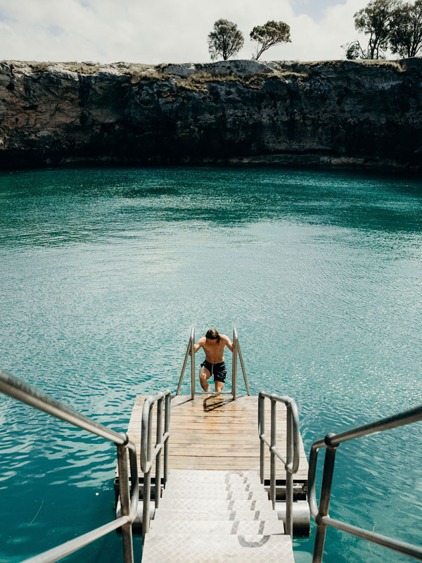 a man climbing up the stairs at Little Blue Lake, Mt Gambier