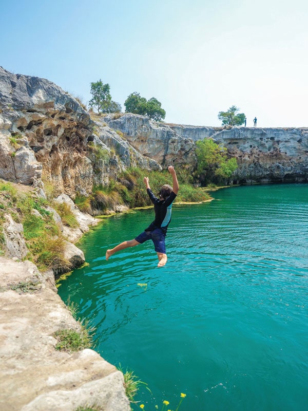 a man jumping into the Little Blue Lake, Mt Gambier