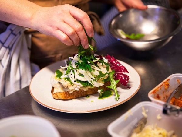 a hand garnishing a meal at My Grandma Ben cafe, Adelaide