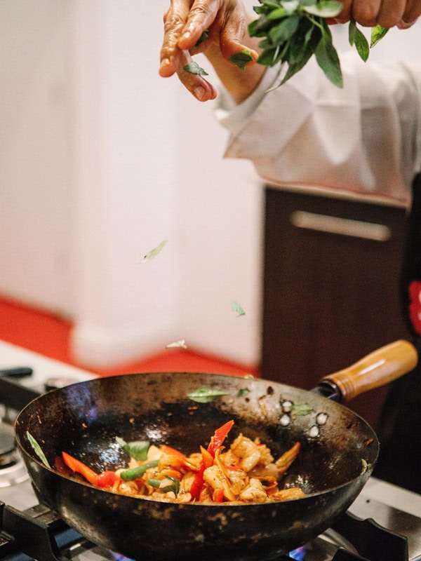 cooking an Asian-style dish in a pan at Sticky Rice Cooking School