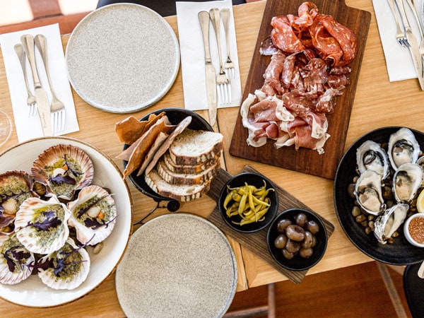 a spread of meat and oysters on the table at Stillwater in Launceston