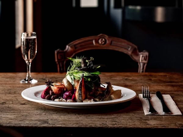 a chicken dish with a glass of wine on the table at The Royal Oak Hotel