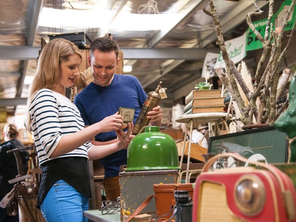 a couple browsing through antique items at The Warehouse at Woodside